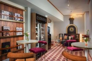 a restaurant with two tables and purple chairs at Avani Palazzo Moscova Milan Hotel in Milan