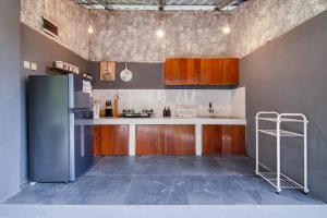 PasirpogorにあるVilla Azzahra Syariahのキッチン(木製キャビネット、ステンレス製の冷蔵庫付)