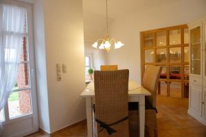 a kitchen and dining room with a table and chairs at Lütje Huus in Norden