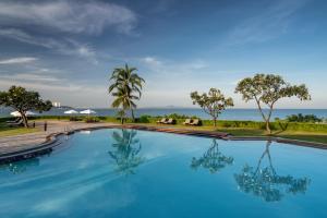 a swimming pool with a view of the ocean at Dusit Thani Pattaya in North Pattaya