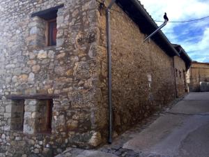 un viejo edificio de piedra con un pájaro a un lado. en Casa Rural El Boixar - El Mirador, en Bojar