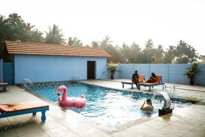 a swimming pool with swans and people in the water at Deshadan Chola , Thanjavur in Thanjāvūr