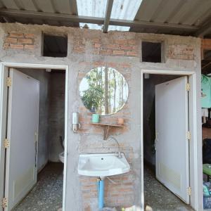 a bathroom with a sink in a brick wall at Green Garden Food Forest Buriram in Ban Thung Nak