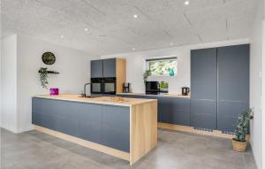 una grande cucina con armadi blu e bancone di Awesome Home In Ebeltoft With Sauna a Ebeltoft