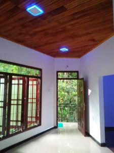 an empty room with two windows and a wooden ceiling at Kelani Riverside Retreat in Kitulgala