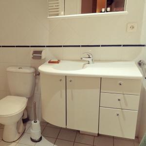 a white bathroom with a toilet and a sink at La La Loc in Cosne Cours sur Loire