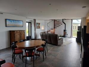 a living room with a wooden table and chairs at Au bon coin de la baie in Vains