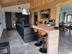 a kitchen with a counter with stools in it at Au bon coin de la baie in Vains
