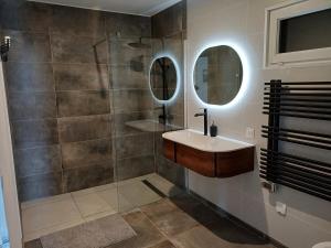 a bathroom with a sink and a shower at Au bon coin de la baie in Vains +10 photos