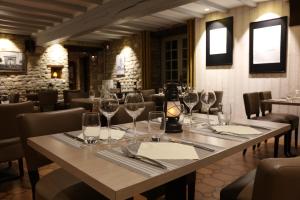 a table in a restaurant with wine glasses on it at Auberge le John Steele in Sainte-Mère-Église