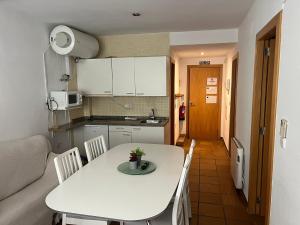 a small kitchen with a white table and chairs at IMEDA apartamentos ARTTYCO con parking in Sierra Nevada +15 photos