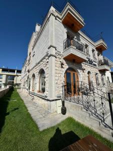a large stone building with a balcony on top at Elite Rose Cappadocia in Uchisar