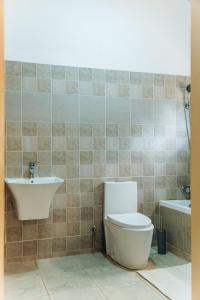 a bathroom with a toilet and a sink and a tub at Affordable Homely Apartment 2 in Namulanda