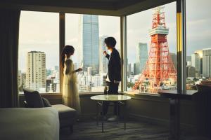 a man and woman standing in a hotel room looking out the window at The Prince Park Tower Tokyo - Preferred Hotels & Resorts, LVX Collection in Tokyo