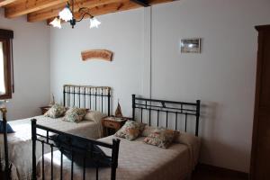 2 letti in una camera da letto con pareti bianche di La Chimenea de Soria I y I I a Espeja de San Marcelino