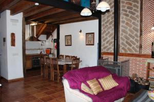 un soggiorno con un divano viola e una cucina di La Chimenea de Soria I y I I a Espeja de San Marcelino