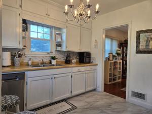 a kitchen with white cabinets and a chandelier at Two Bedroom Home Close to Mayo Clinic in Rochester