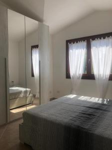 a bedroom with a large bed and a mirror at Bellavista San Teodoro appartamento vista mare in Lu Lioni