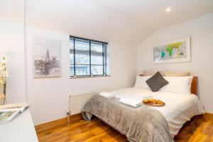 a bedroom with a bed with a tray of food on it at Cuthbert Suite - Heart of Covent Garden! in London