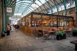 a restaurant in a building with tables and chairs at Cuthbert Suite - Heart of Covent Garden! in London
