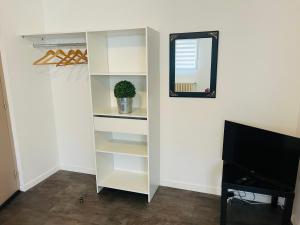 a white closet with a mirror and a tv at Le 2 - Grand studio Caen Centre Port de plaisance in Caen