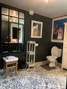 ein Bad mit einem WC, einem Tisch und einem Spiegel in der Unterkunft Charmante maison proche des châteaux de Loire in Baule