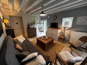 ein Wohnzimmer mit einer Couch und einem Couchtisch in der Unterkunft Charmante maison proche des châteaux de Loire in Baule