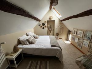 ein Schlafzimmer mit einem großen weißen Bett im Dachgeschoss in der Unterkunft Charmante maison proche des châteaux de Loire in Baule