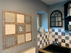 eine Küche mit einer Spüle und einer Fliesenwand in der Unterkunft Charmante maison proche des châteaux de Loire in Baule + 15 Fotos