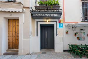 a door to a building with a table and chairs at Posada de los Venerables in Seville