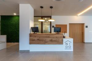 an office with a reception desk with a tv on it at NIDO Malvarrosa Hotel - Apartamento in Valencia