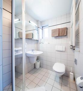 a white bathroom with a toilet and a sink at Nürnberger Trichter Family-Business Hotel Garni in Nürnberg