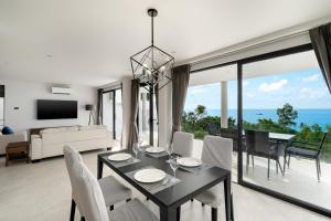 Una sala de estar con una mesa y sillas y un sofá. en Penthouse 2BR Seaview Top Floor, en Ban Thong Phlu