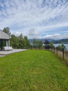 a park with a bench and a view of the water at Seaside Holiday Home in Hjelmeland