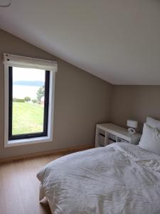 a bedroom with a large bed and a window at Seaside Holiday Home in Hjelmeland