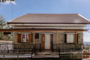 a small house with two benches in front of it at Stylish Stonehouse in Platres in Platres