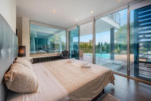 a bedroom with a large bed and a large window at Villa Rockstar, Alcudia - by EMERALD STAY in Alcudia +28 photos