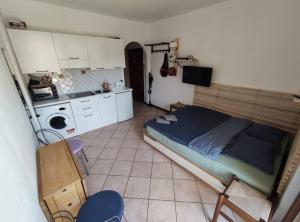 a small room with a bed and a kitchen at Tennis & Swim Apartment in Germignaga