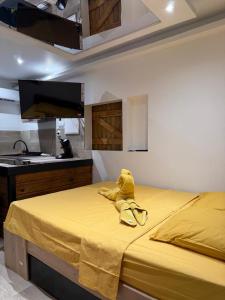 a yellow bed with a towel on top of it at Love Room Ô Fruit de la passion in Le Gosier