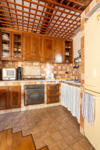 a kitchen with wooden cabinets and white towels at Accogliente Casa Antica, nelle vicinanze di Roma in Frascati +8 photos