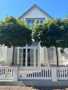 ein weißer Zaun vor einem Haus in der Unterkunft Groot Huus in Norderney