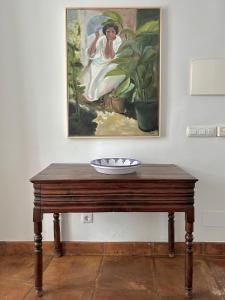 una mesa de madera con una pintura en la pared en Namaste, en Grazalema