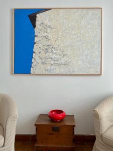 un cuenco rojo en una mesa frente a una pintura en Namaste, en Grazalema