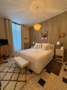 une chambre avec un grand lit et un lustre dans l'établissement La Rose des Vins, à Pouzolles