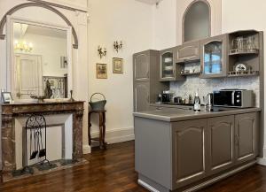 a kitchen with a counter and a fireplace at Châtel Rose - Historical Centre with Garden in Blois