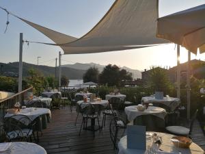 a deck with tables and chairs on a deck with mountains at Hotel Danila in Portoferraio