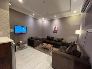 a living room with couches and a flat screen tv at Golden square قولدن سكوير in Khamis Mushayt