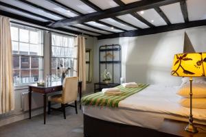 a bedroom with a bed and a desk and window at Whyte Harte Hotel in Bletchingley
