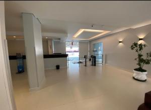 an empty lobby with a potted plant in a building at Flat próximo ao Shopping e Praia in São Vicente