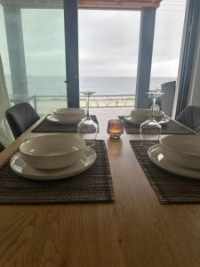 a table with plates and wine glasses on top of it at Saos Terra Suites in Samothraki